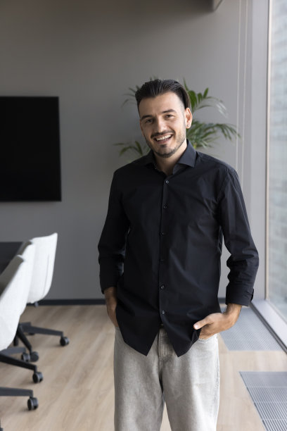 在现代办公室里随意站立的开朗有魅力的企业主图片下载