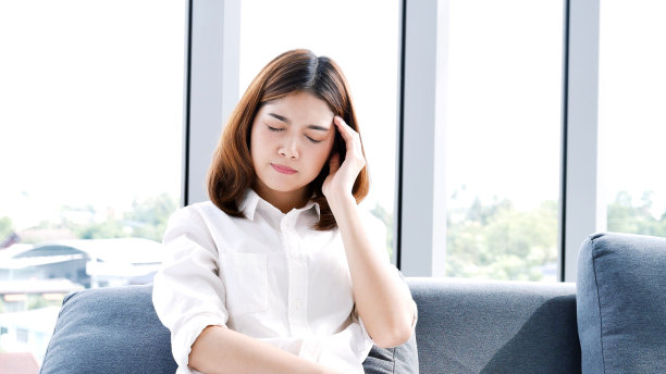 压力亚洲女性头痛有偏头痛感觉太阳穴紧张不安抑郁。强烈的头痛偏头痛使年轻的女孩精疲力竭。办公室综合症不健康紧张的人。女性头痛概念图片下载