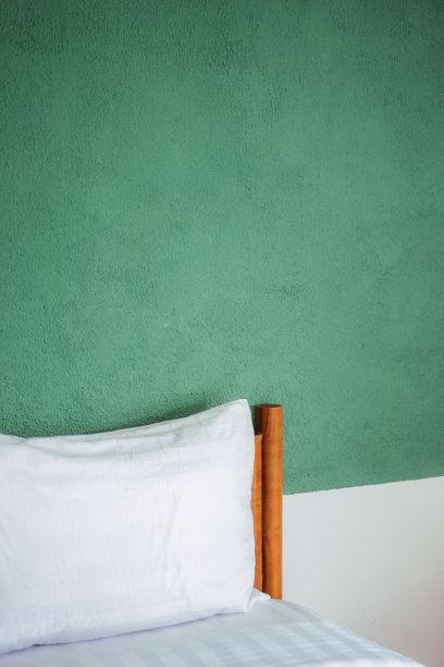木床床头板与枕头绿墙的特写图片下载