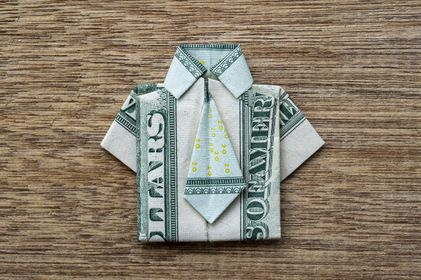 木制背景的美元纸钞折纸衬衫。近距离图片下载