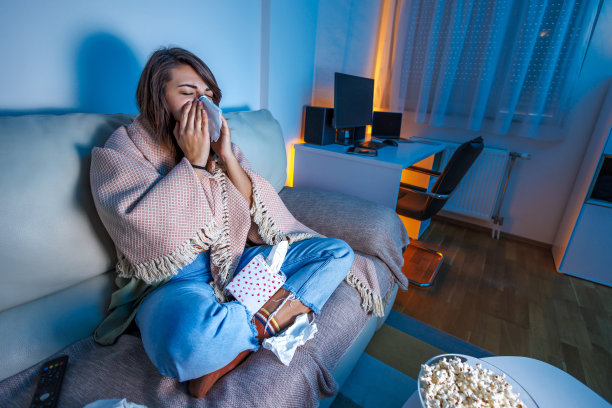 擤鼻涕的女人生病在家看电视图片下载