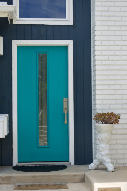 明亮的绿松石正门通向一座中世纪的现代海滨平房图片下载