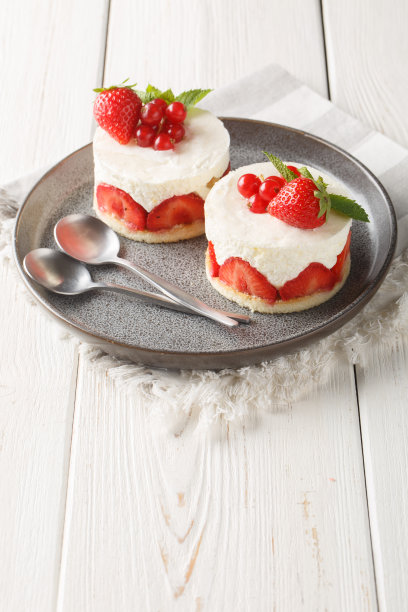 法式迷你蛋糕冷盘，配上新鲜草莓和红醋栗。垂直图片下载