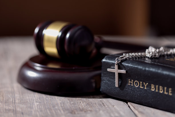 餐桌背景上有圣经书和法官的小木槌。司法制度、宪法、民主、法治。照片里没有人。有可以插入的空闲空间。图片下载