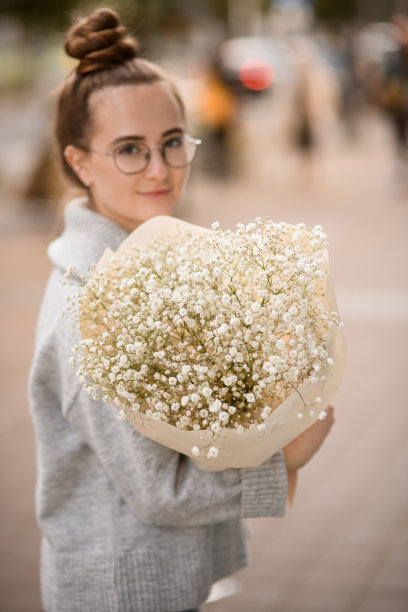 选择性聚焦于女人手中的白色吉卜赛花花束图片下载