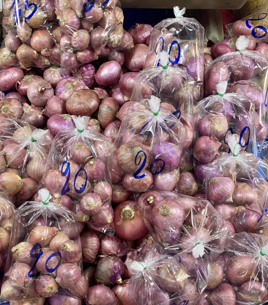 这是一堆洋葱的照片，上面贴着价格标签，杂货店里的洋葱都贴着价格标签。图片下载