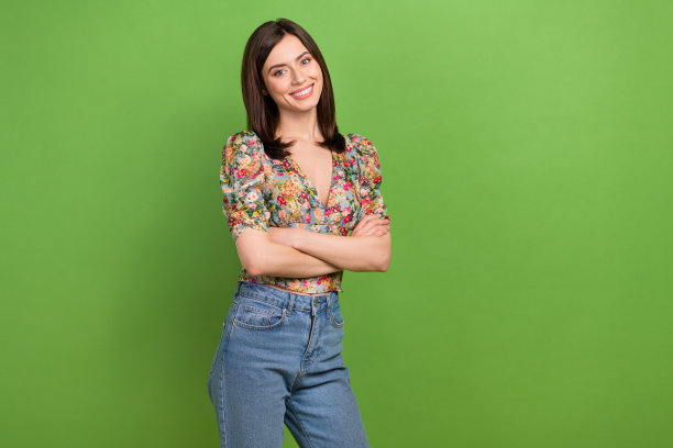 照片漂亮的女士促销员抱臂交叉自信的年轻专业工人孤立的绿色背景图片下载