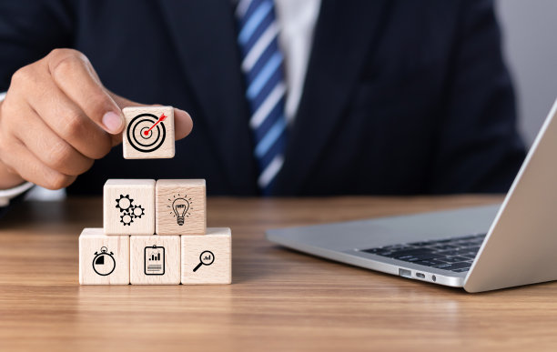 企业战略的概念和未来可持续的企业财务行动计划。商人手持木块立方体与图标公司战略发展，概念成功和业务目标。图片下载