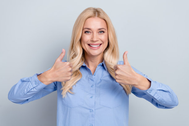 开朗的成熟女办公室职员的照片肖像竖起大拇指，赞成质量好孤立的灰色背景图片下载