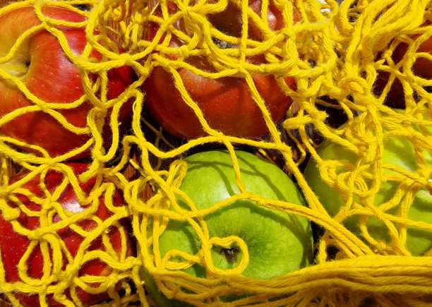 多汁的苹果红色和绿色在黄色环保袋。健康的生活方式。极简风格的特写照片。手机壁纸图片下载