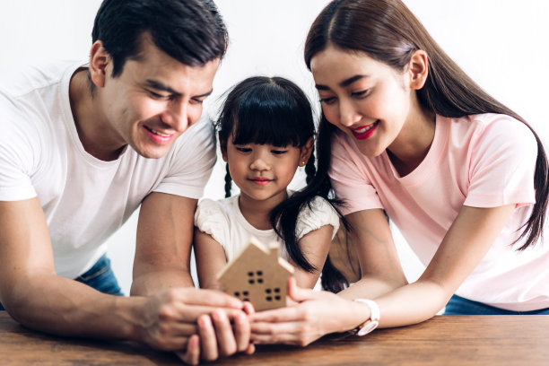 幸福的家庭握着房子。房地产概念图片下载