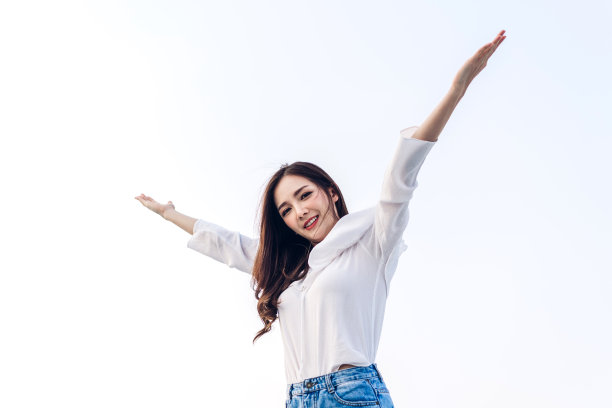 站着的女人伸展双臂，放松地享受着大自然的新鲜空气图片下载