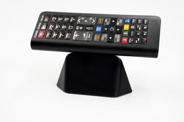 这张图片显示了一个电视遥控器的正面，遥控器上有一个白色背景的按钮系统，可以从卫星天线或互联网上选择节目。图片下载