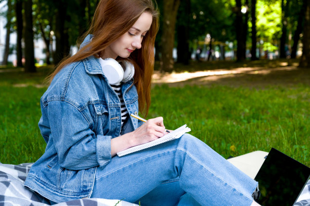 一个快乐的学生做笔记的侧视图。远程教育概念。大学或学院的概念。图片下载