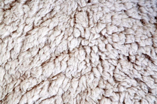 天然毛绒绒的羊皮质地。米色地毯背景设计。hygge。图片下载