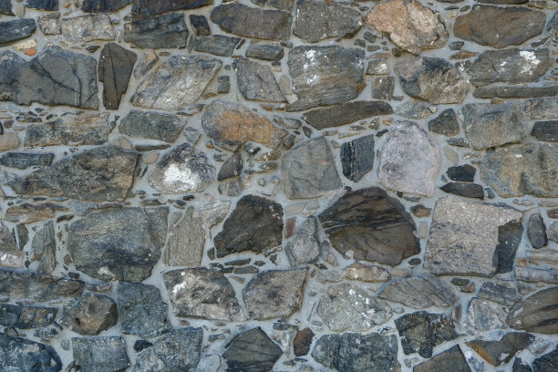 一个美丽的历史石墙的正面视图，有各种颜色的石头，石灰沉积物和砂浆图片下载