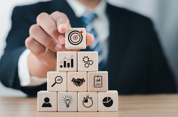 企业战略的概念和未来可持续的企业财务行动计划。商人手持木块立方体与图标公司战略发展，概念成功和业务目标。图片下载