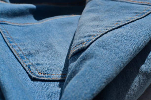 一条牛仔裤的缝纫线特写，展示了制造过程中的细心和技巧。非常适合时尚和风格相关的项目。图片下载
