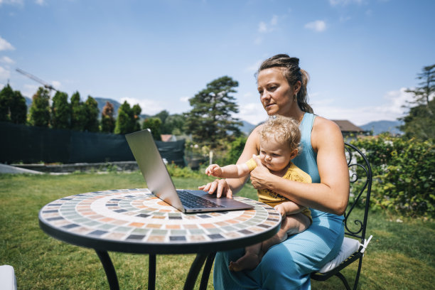 母亲和婴儿在户外用笔记本电脑工作图片下载