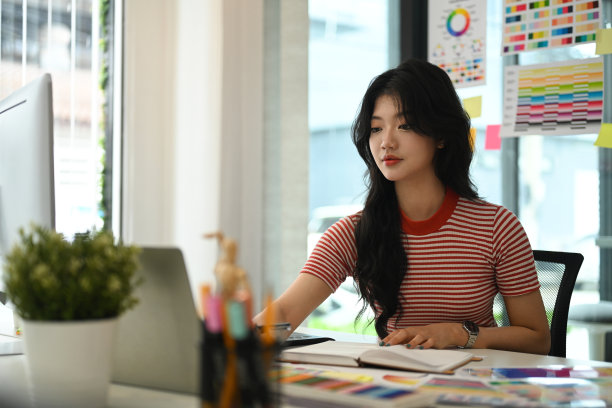 年轻的平面设计师在工作空间工作。图片下载