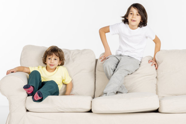 两个男孩在沙发上玩。图片下载