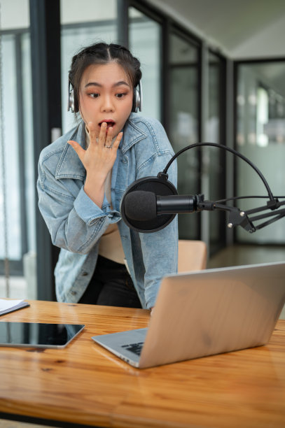 一位震惊的亚洲女电台主持人或电台记者正对着麦克风讲话图片下载