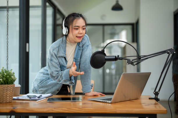 一位美丽的亚洲女电台主持人或电台记者正对着麦克风讲话图片下载