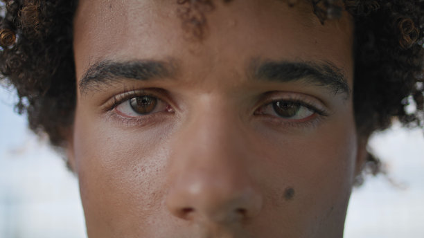 对焦的家伙盯着镜头在户外极端特写。卷曲模型相机图片下载