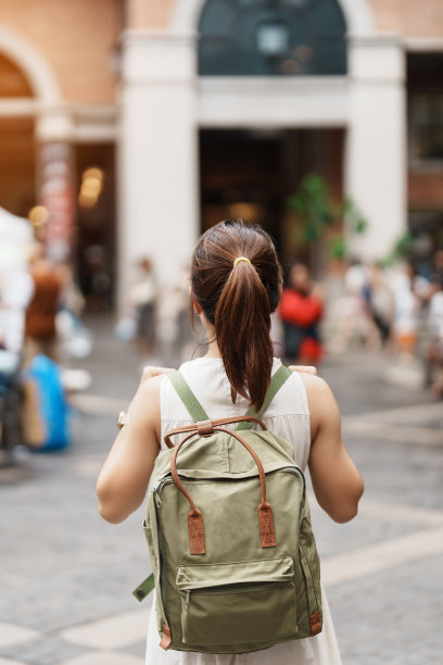 在泰国清迈的夜市，一名年轻的亚洲女游客身穿黄色连衣裙，带着包前往尼曼海明路上的尼曼。亚洲旅游、度假及暑假图片下载