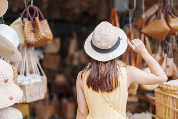 年轻的亚洲女游客穿着裙子，戴着帽子，前往常迈高路上的柳条店，游客在泰国常迈老城参观。亚洲旅游，度假和暑假的概念图片下载