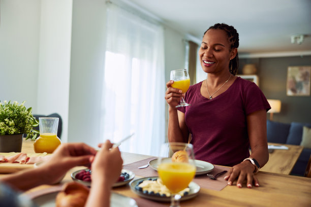 微笑的非裔美国妇女在家里享用美味的早餐。图片下载