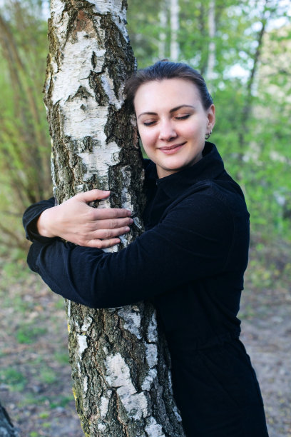 年轻黑发女子抱着一棵树的肖像图片下载