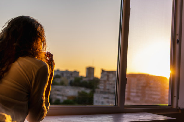 从窗口看日落的女人图片下载
