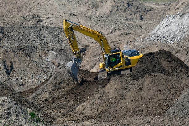 土方工程，开发，施工现场:在具有不同底土的巨大开发区域中，铲式挖掘机与土和砾石的鸟瞰图图片下载