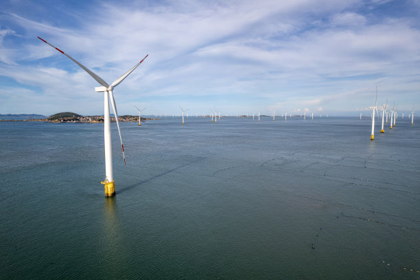 阳光明媚的一天，海上的一组风力涡轮机图片下载