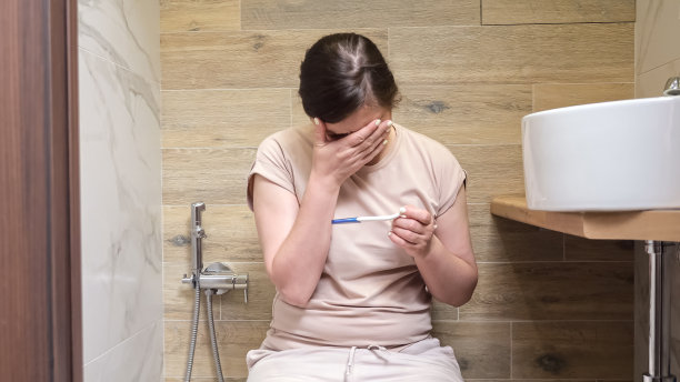 女性坐在马桶上学习怀孕图片下载