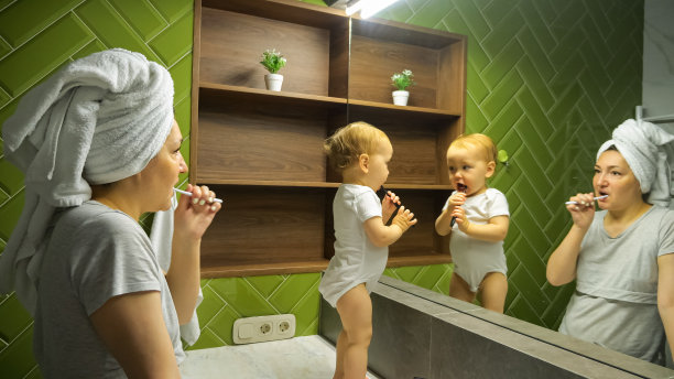 女人和小孩看着大镜子刷牙图片下载