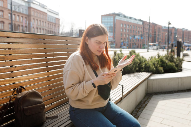 特写肖像沮丧悲伤，怀疑，不快乐，严肃的女人看着手机屏幕在外面。消极的人类情绪，面部表情感觉，生活反应。坏消息图片下载