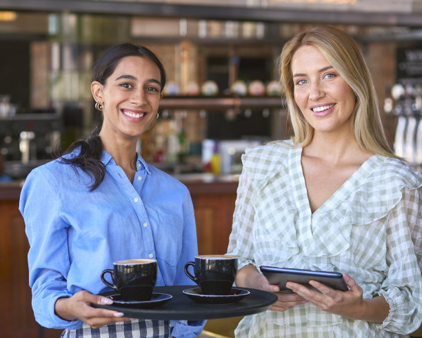拿着数码平板电脑的女经理和在餐厅或咖啡店工作的女服务员的肖像图片下载
