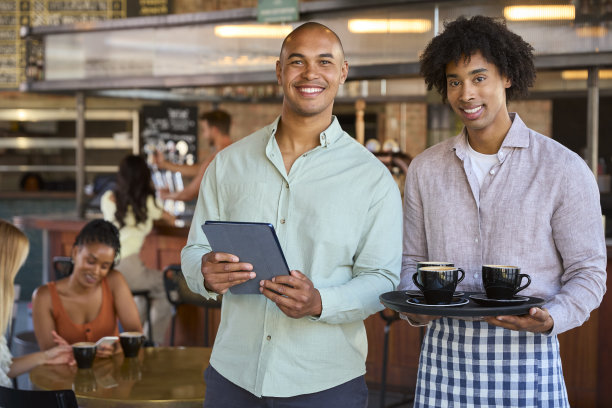 拿着数码平板电脑的男经理和在餐馆或咖啡店工作的服务员的肖像图片下载