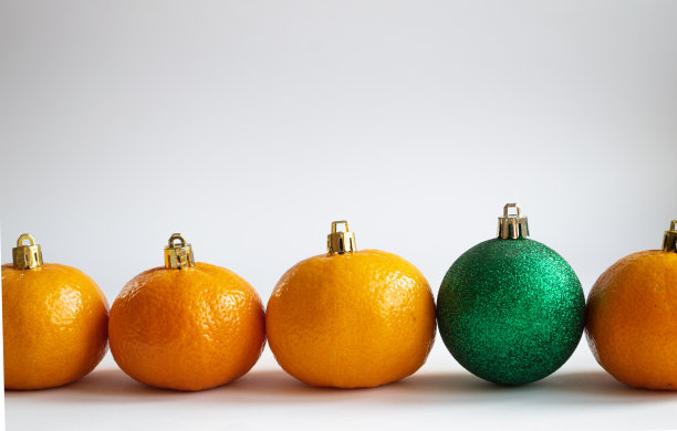圣诞装饰形式的橘子和新年玩具一起排成一排图片下载