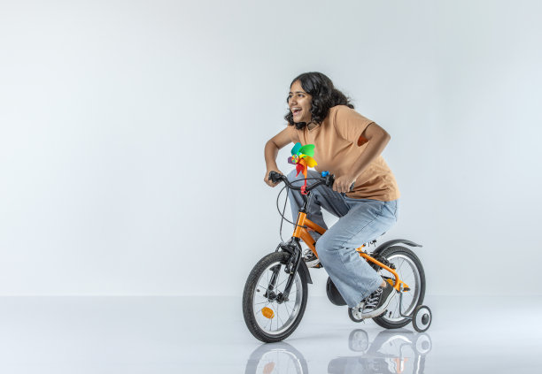 开朗的少女在白色背景上骑自行车图片下载