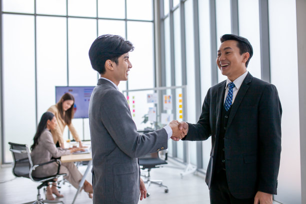 团队合作交易合作伙伴关系商务人士握手，在办公室里两个商务人士握手。图片下载