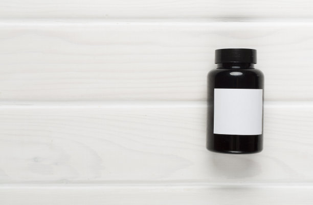 木制背景上的维他命塑料瓶，俯视图图片下载