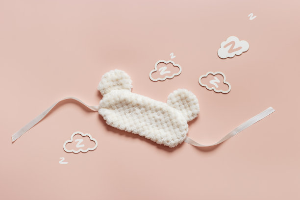 睡眠面具从柔软的漂亮的皮毛和云形状与zz鼾声在粉红色的背景。轻蓬松的眼罩，最好的睡眠。旅行舒适，梦想美好，晚上休息，最小化的理念图片下载