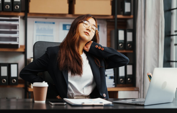 穿着正装的女商人和压力性疼痛，包括背痛、痤疮和其他皮肤问题，如皮疹、荨麻疹。头痛。图片下载