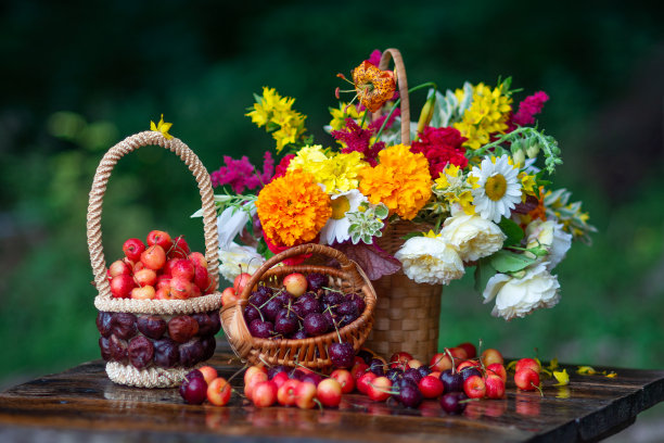 艺术静物与花束花园的鲜花和樱桃在一个篮子里的木桌对一个黑暗的背景图片下载