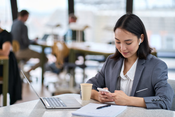 年轻的亚洲女商人在工作中使用智能手机。横幅图片下载
