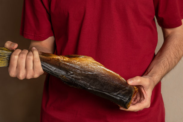 一个面目全非的年轻人手里拿着漂亮的烟熏粉红鲑鱼图片下载