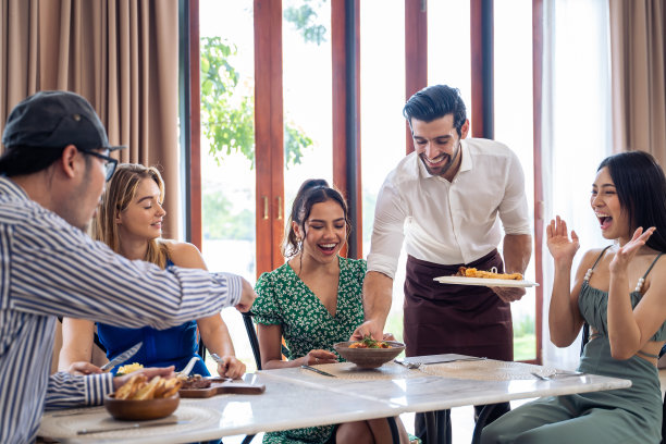 一群不同的朋友在餐厅里聊天、吃饭。有魅力的年轻男女让人们感到快乐和放松，在室内玩乐，在咖啡馆聚会和团聚。图片下载